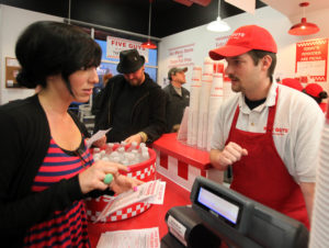 Marcus Haizlip, general manager at the new Five Guys Burger and Fries in Santa Rosa takes the order of Alissa De La Riva, Feb. 15, 2011 | Crista Jeremiason, PD