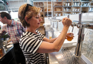 Cindy Daniel, owner of the Shed, draws some draft wine from the fermentation bar. (photo by Chris Hardy)