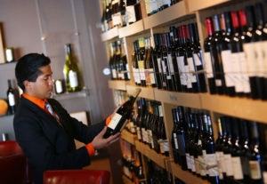 Beverage director Jordan Nova selects a bottle from the many featured wines at 1313 Main in Napa on Friday, October 11, 2013. (Conner Jay/The Press Democrat)