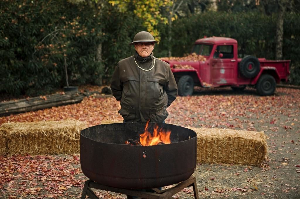 Rodger Warnecke warms himself by the fire at a barbecue at the ranch. (photo by Chris Hardy)