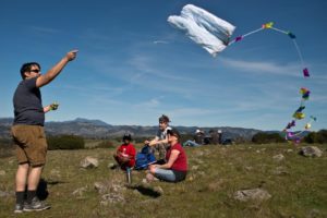 Seth Schwebs, left sets a kite aloft while Temesgen Schwebs, Steven Johansen and Kristen Schwebs share snacks during a hiking break at the Taylor Mountain Open Space in Santa Rosa. (Alvin Jornada / The Press Democrat) 