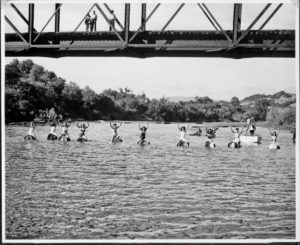 At The Races: Entrants in a 200-yard wine-barrel race on the Russian River raise their paddles as a few admirers look on from Healdsburg Veterans Memorial Bridge. The race was part of the 1947 Healdsburg Harvest Festival, attended by thousands. (Courtesy Sonoma County Wine Library)