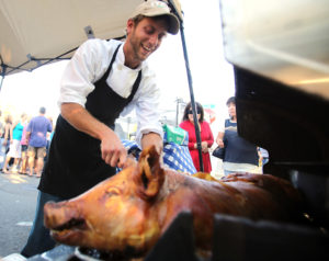 Joe Rueter, chef with the Green Grocer, serves a porchetta during Windsor's Farmers Market on the Town Green, June 14, 2012. 