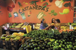 Albina Rodriguez holds a papaya for Luz Falcon and her 2-year-old daughter, Sofia, to smell at Castañeda's Marketplace in Windsor. (photos by John Burgess)