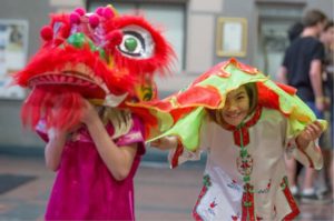 Keelyn Walker, right, peeks from under a lion costume while Brook Szczekocki greets guests arriving for a Chinese New Year celebration at the Veteran's Memorial Building in Santa Rosa on Saturday, Feb. 21, 2015. The Redwood Empire Chinese Association hosted the event honoring the year of the Ram. (Jeremy Portje / For The Press Democrat)