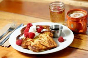 Cinnamon French toast made from Village Bakery brioche topped with butter, fresh whipped cream, organic raspberries and real maple syrup with sparkling wine and a cappuccino at Estero Cafe in Valley Ford. (Alvin Jornada / The Press Democrat)