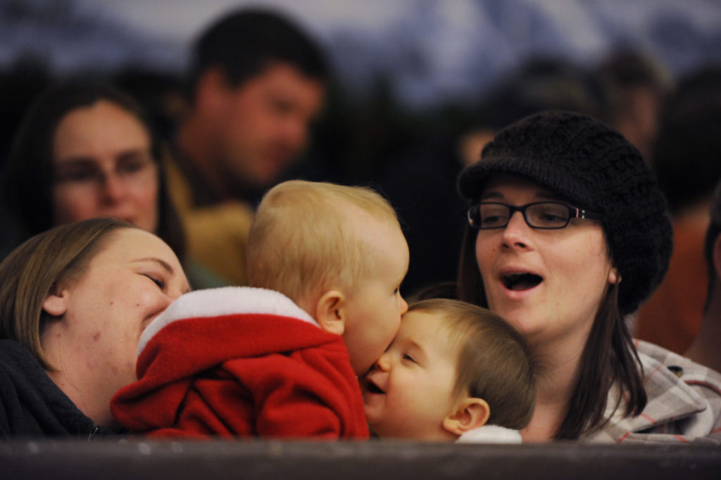 Angel Hellgren (far left) and Heather Lore (far right) watch nine-month-olds Lily Hurley and Addison Lore kiss during the Snoopy ice show and holiday tree-lighting event held Friday evening at the Redwood Empire Ice Arena in Santa Rosa. December 2, 2011 (Photo: Erik Castro/for The Press Democrat)