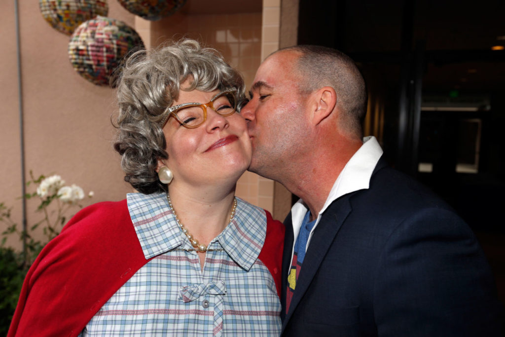 Hunter Wilkinson kisses his wife, SAY chief operating officer Katrina Thurman, in costume as Super-Grandma, during the Here We Come to SAY the Day fundraiser for Social Advocates for Youth, at the Friedman Center in Santa Rosa, California on Saturday, May 14, 2016. (Alvin Jornada / The Press Democrat)