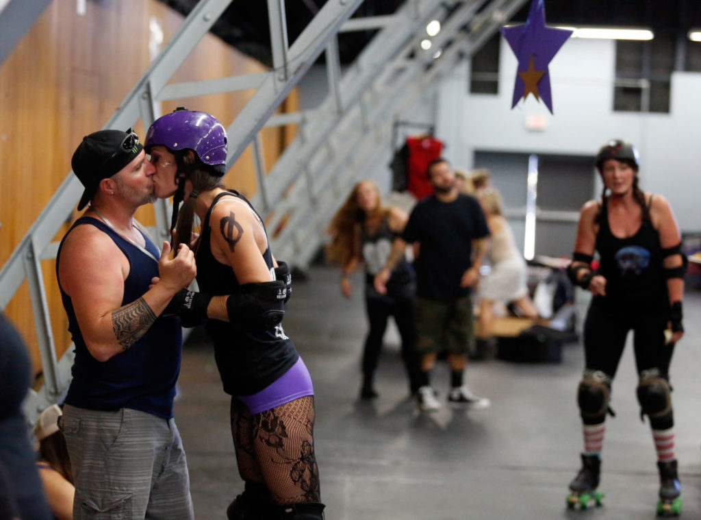Chris Bradford kisses his wife "Rowdy Bout It" of the Wine Country Homewreckers before her roller derby match against the Faultline Derby Devilz at Grace Pavillion in Santa Rosa, California, on August 22, 2015.