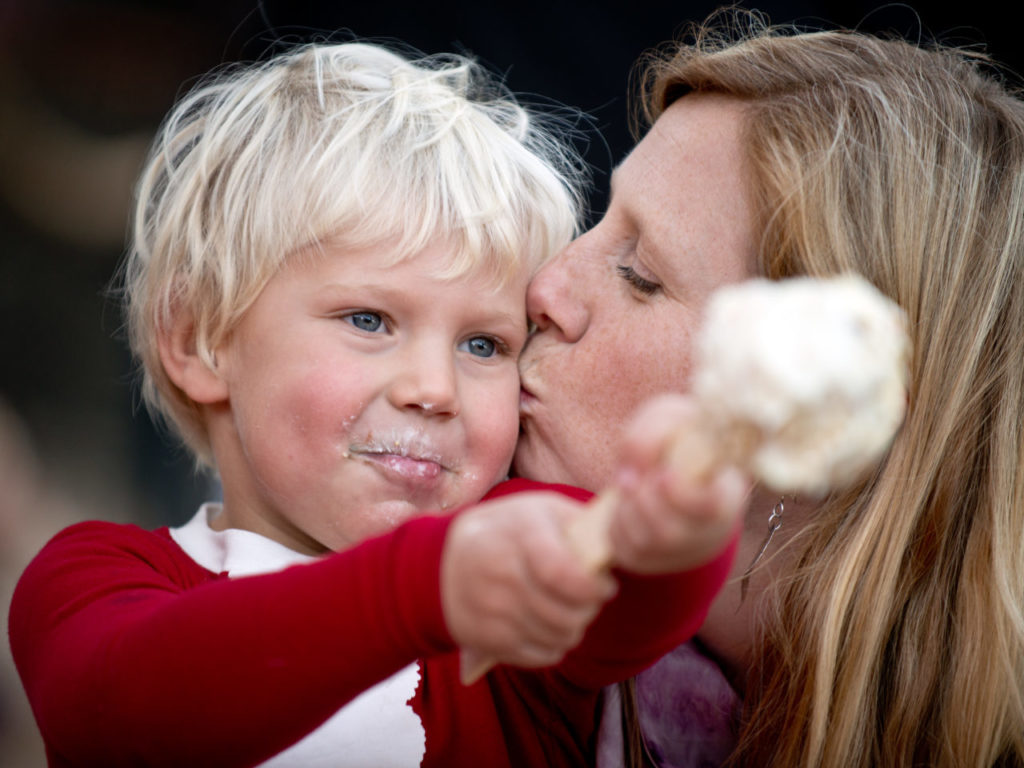 Caleb Wirts, 3, gets a kiss from his mother Erin while he eats his popcorn ball during the Lighting of the Snowmen Festival at Cornerstone Sonoma in Sonoma, Calif., on December 8, 2013. (Alvin Jornada / The Press Democrat)