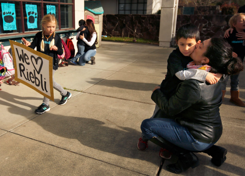 Najia Said, right, hugs and kisses her son Raiden Fulton, 5, before he enters his kindergarten classroom at John B. Riebli Elementary School, where students returned for the first time since the Tubbs Fire damaged the school and decimated the surrounding Larkfield-Wikiup neighborhood, in Santa Rosa, California on Friday, December 22, 2017. (Alvin Jornada / The Press Democrat)