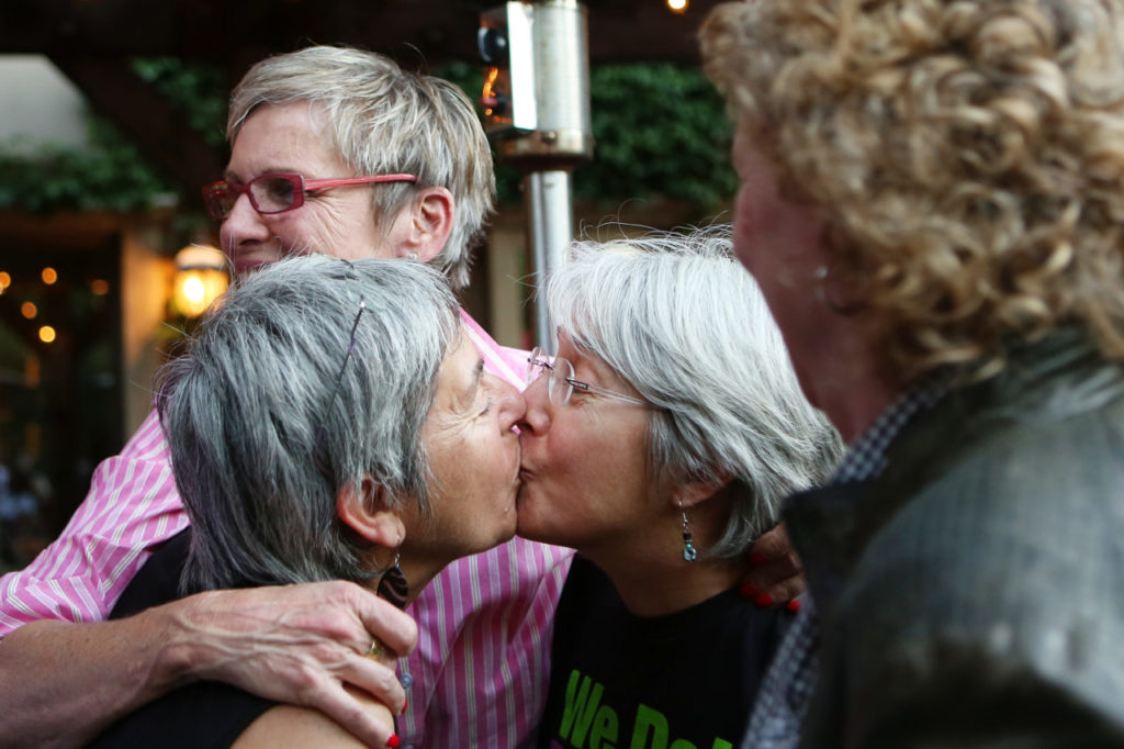 6/30/2013: B2: PC: Joan Longfeld, left, and Susie Jungfaru kiss while while celebrating the Supreme Court rulings restoring same-sex marriage to Californians during a celebration in Healdsburg on Wednesday, June 26, 2013. Longfeld and Jungfaru have been tried to get married in 2004 and then again in 2008, and have been together for the past 35 years. (Conner Jay/The Press Democrat)