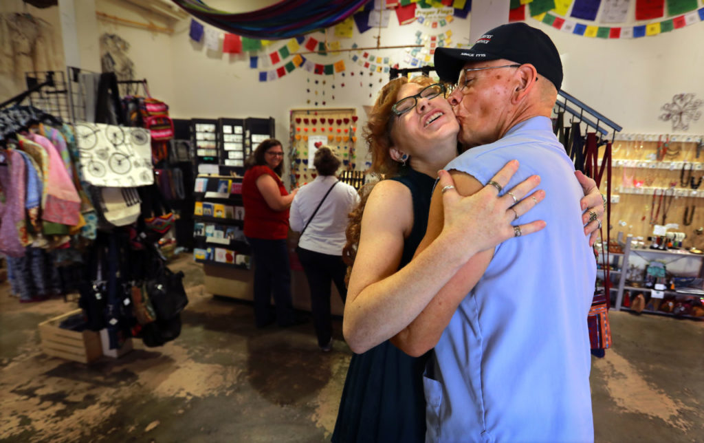 Mail carrier Butch Alvarez kisses Lucy Sweatt, the manager of Global Heart Fair Trade on the next to the last day of work for Alvarez who has been delivering mail on the plaza in Sonoma for 33 years of his 40 year career. (photo by John Burgess/The Press Democrat)