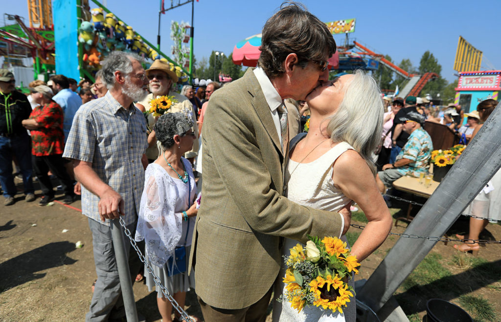 Virginia and David Goodison renewed their wedding vows at the Sonoma County Fair in Santa Rosa, Friday August 11, 2017 with over two dozen others on the midway Century Wheel. (Kent Porter / Press Democrat) 2017