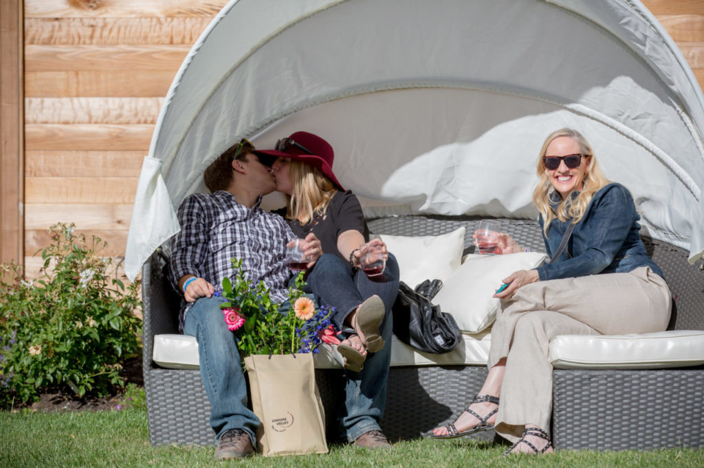 Clinton Tjensvold and Christie Pitts kiss while Karen Zachary smiles during Sunset Magazine's Celebration Weekend at Cornerstone near Sonoma, Calif. Saturday, May 14, 2016. Guests were invited to join editors, celebrity chefs, vintners, craft beer brewers and lifestyle experts for a two-day series of culinary, wine, garden and lifestyle events. (Jeremy Portje / For The Press Democrat)