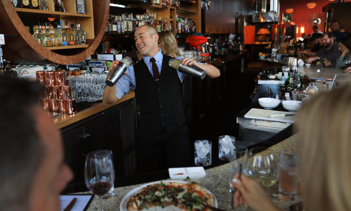 SRJC swimmer Nate English mixes drinks as he bartends at Jackson's Bar and Oven in Santa Rosa, Friday March 16, 2018. (Kent Porter / The Press Democrat) 2018