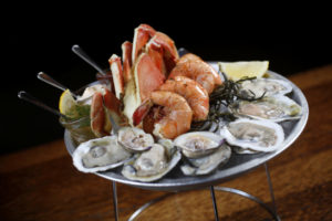 The medium seafood platter with peel and eat Gulf prawns, Blue Point oysters, littleneck clams, and half a Dungeness crab with a variety of dipping sauces at Willi's Seafood and Raw Bar in Healdsburg. (Beth Schlanker/The Press Democrat)