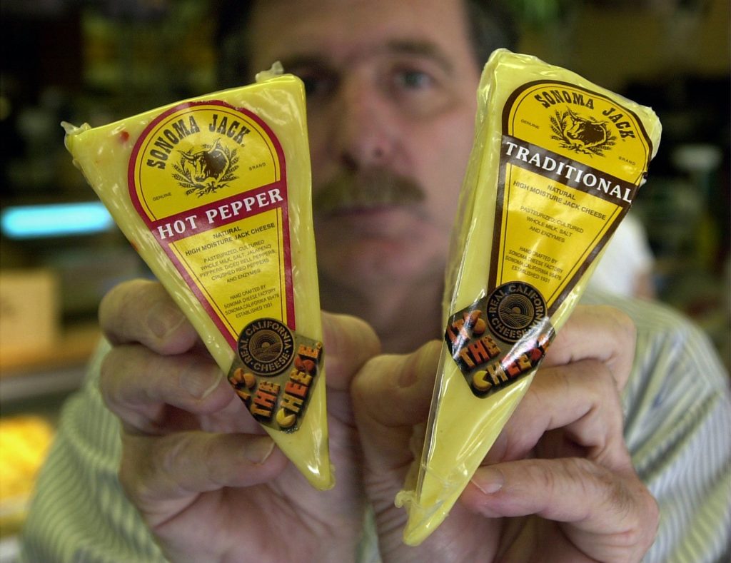 Sonoma Cheese Factory president David Viviani holds the cheese being made for them in Crescent City, left, which cannot make the the traditional wheel of cheese for their Sonoma Jack, which has a rounded top, right.
