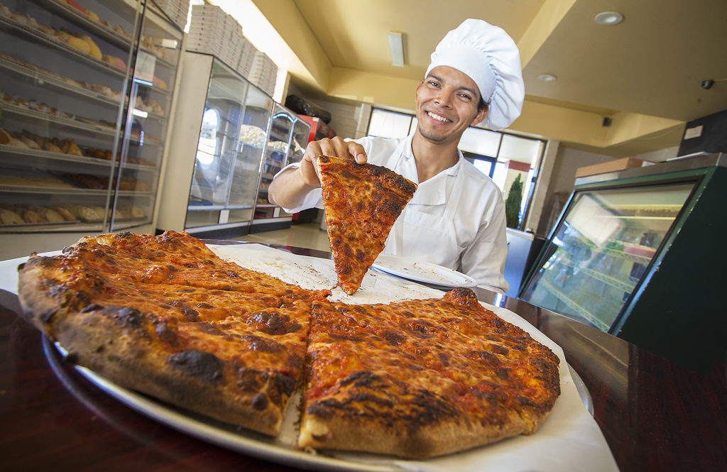 Fernando Garcia insists that it's the charred crust that makes his an authentic New Haven pizza. He shares shop space at the Garcia Bakery on Fifth Street West. (Photo by Robbi Pengelly/Index-Tribune)