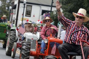 Roy Cole, center, rides an antique tractor during Penngrove's 39th annual "Biggest Little Parade" on Sunday, July 5th 2015, in Penngrove, California.