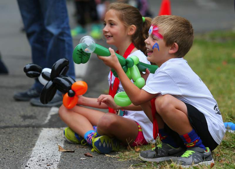 Luke Bronzan, 5, and his sister, Olivia, 8, cheer for their mom running in the 10K race, after competing in the 3K event of the Kenwood Footrace, in Kendwood, on Monday, July 4, 2016.