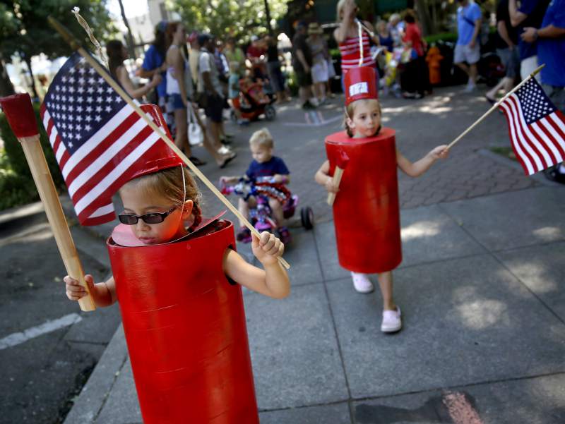 Dressed as firecrackers, Malia Hughes,, left, and her twin sister, Brooke, take part in the Fourth of July Kids' Parade at the plaza in Healdsburg in 2014.