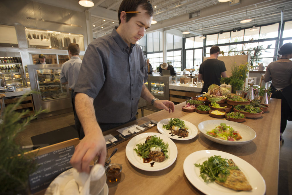 Chef Perry Hoffman making final touches to dishes before they head out to the dining area during a Saturday brunch at SHED in Healdsburg. January 16, 2016. (Photo: Erik Castro/for Sonoma Magazine)