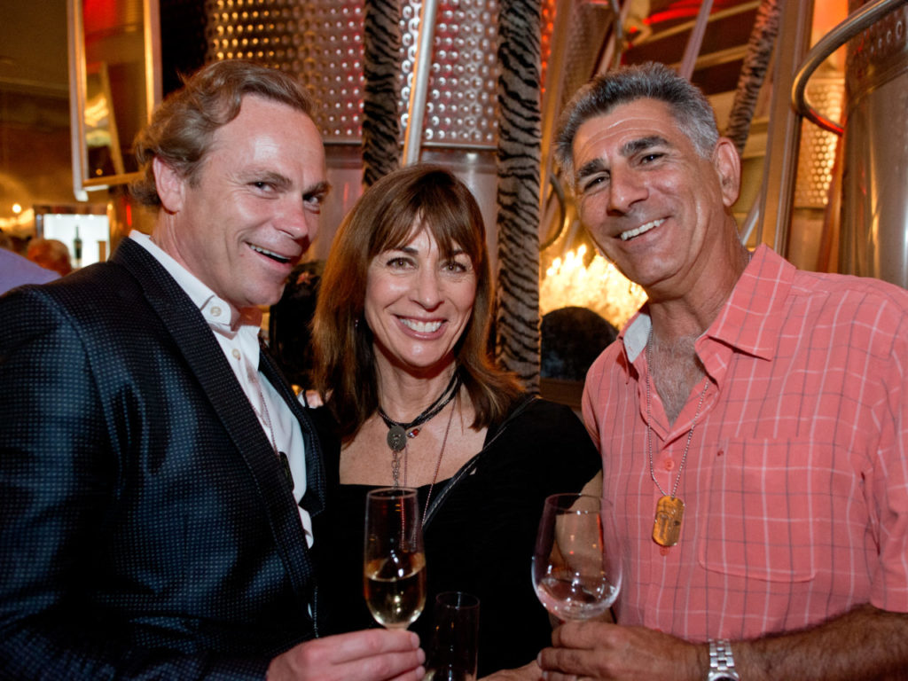 Jean-Charles Boisset, president of Boisset Family Estates, left, with Jennifer and John Mangiantini of Mangiantini Construction, Inc. during Out in the Vineyard's Twilight T-Dance at Raymond Vineyards, benefitting Face to Face Sonoma County AIDS Network, during Gay Wine Weekend in St. Helena, California, on June 14, 2014. (Alvin Jornada / For The Press Democrat)