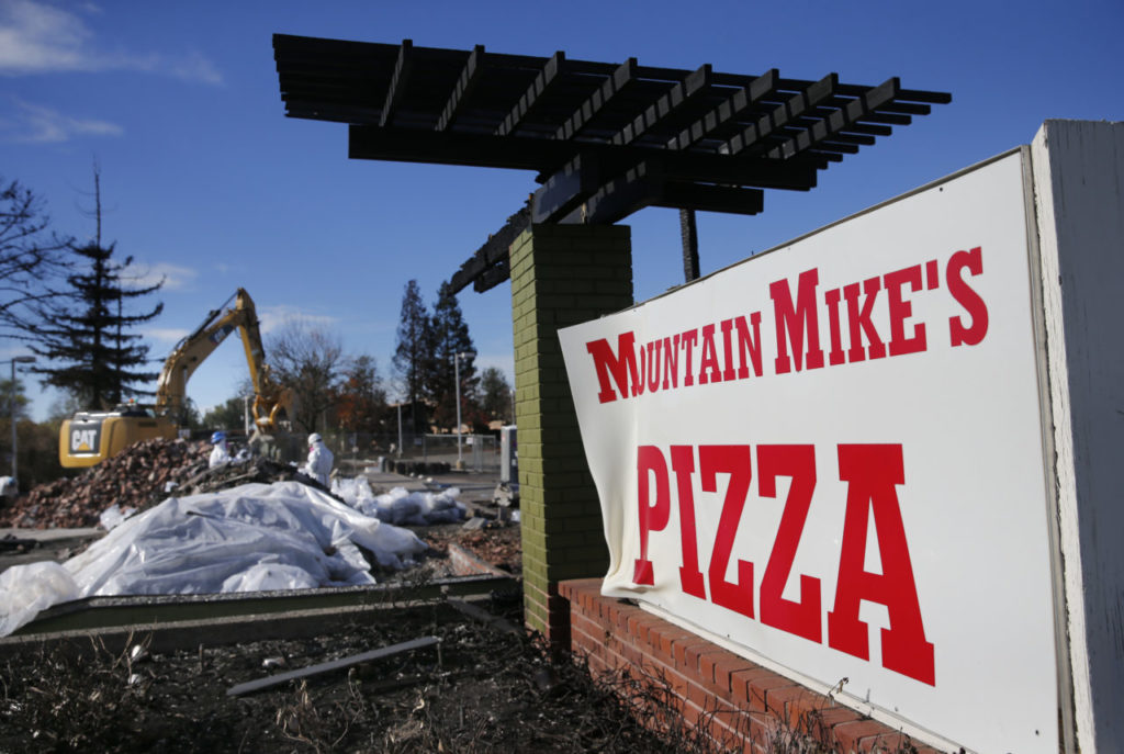 Employees of Excel Site Services clean up burned debris at Mountain Mike's Pizza on Cleveland Ave on Wednesday, November 29, 2017 in Santa Rosa, California . (BETH SCHLANKER/The Press Democrat)