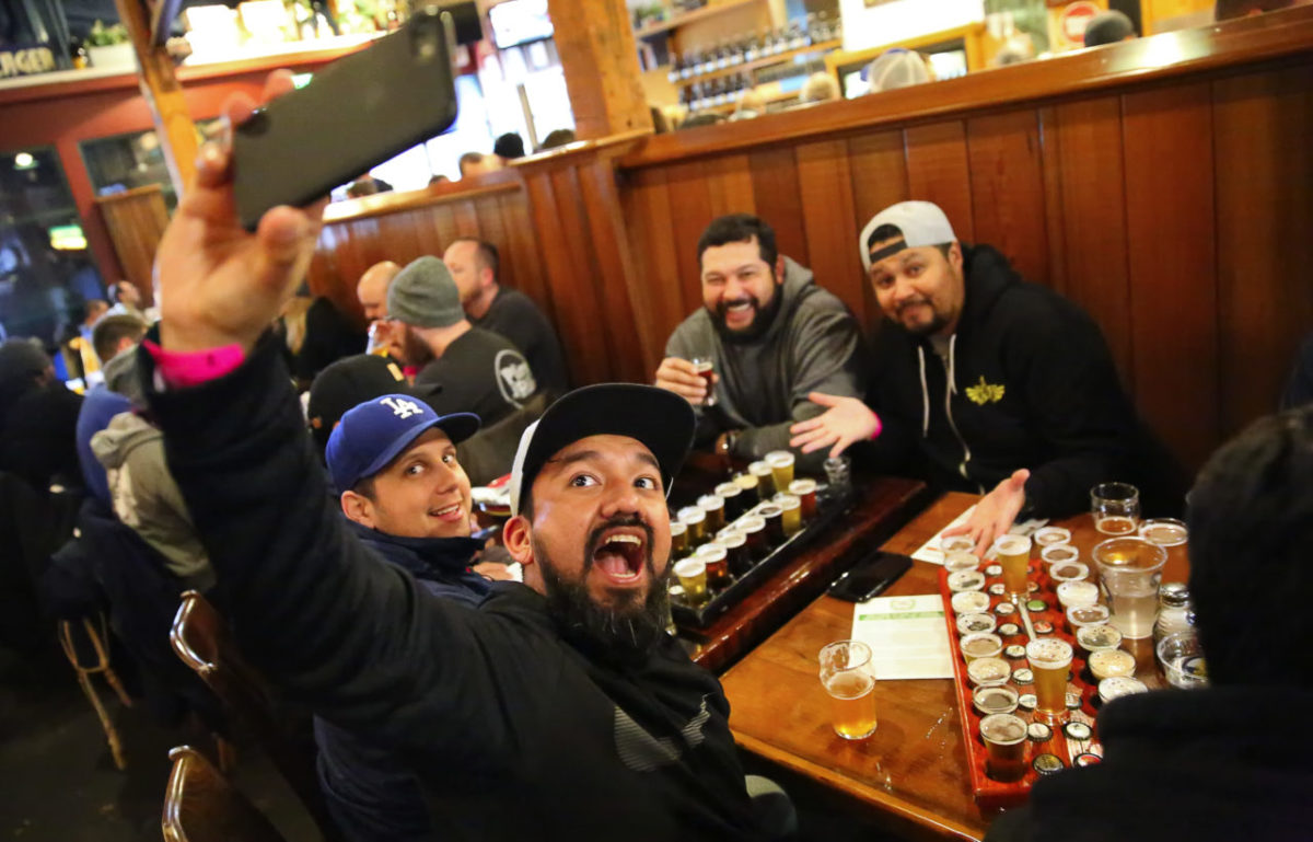 Victor Arrazabal, foreground, shoots a selfie with Sergio Guadron, left, Hernan Tobar, and Victor Arana, at the Russian River Brewing Company, in Santa Rosa, on Friday, February 3, 2017. The friends travelled from Los Angeles for this year's release of Pliny the Younger. (Christopher Chung/ The Press Democrat)