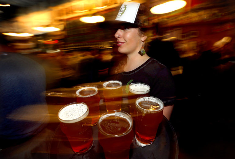Chloe Smith delivers another round of Pliny the Younger at Russian River Brewing Company in Santa Rosa on Friday. (JOHN BURGESS / The Press Democrat)