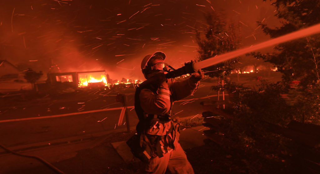 Embers zip through the air as a Cazadero firefighter attempts to thwart the spreads of flames in Coffey park Monday Oct. 9, 2017 in Santa Rosa. (Kent Porter / Press Democrat) 2017