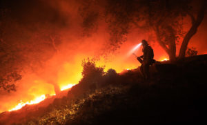 A San Diego Cal Fire firefighter monitors a flare up on a the head of the Nuns fire (the Southern LNU Complex), Wednesday Oct. 11, 2017 off of High Road above the Sonoma Valley. A wind shift caused flames to move quickly up hill and threaten homes in the area. (Kent Porter / Press Democrat) 2017