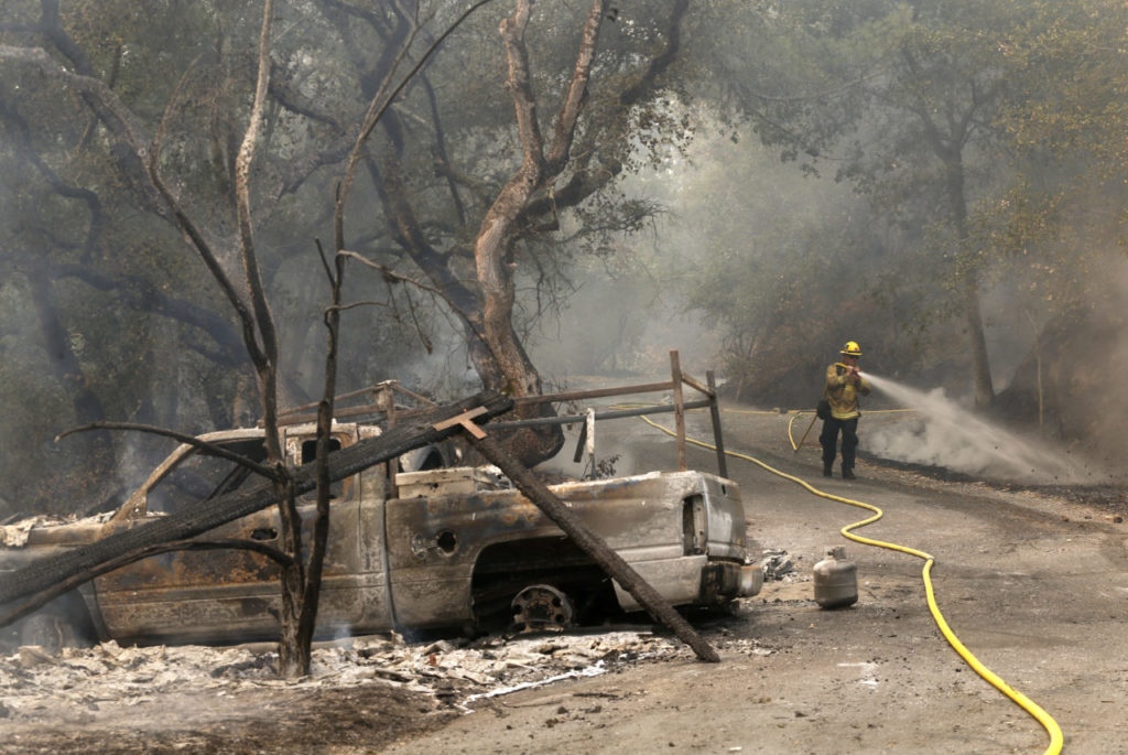 Oxnard fire fighter Nathan Goldie works to put out hot spots on the 3500 block of Lovall Valley Rd on Thursday, October 12, 2017 in Sonoma, California. (Photo by Beth Schlanker) 