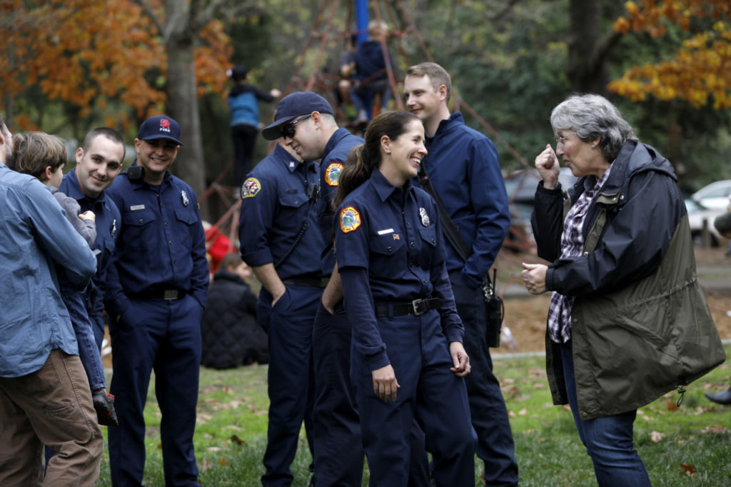Kenwood volunteer firefighter Jen Demarest, center, talks with Janet Uboldi, right, during a community potluck to thank the Kenwood firefighters at Plaza Park in Kenwood, on Sunday, November 12, 2017. (Photo by Beth Schlanker)