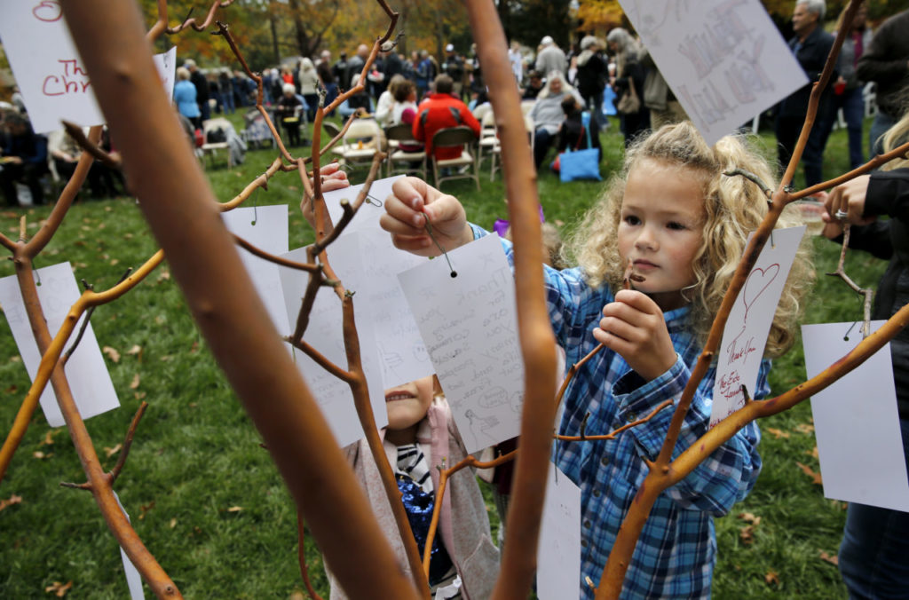 Caroline Philbin, 7, ties a thank you note to firefighters onto a manzanita branch during a community potluck to thank the Kenwood firefighters at Plaza Park in Kenwood, on Sunday, November 12, 2017. (Photo by Beth Schlanker) 