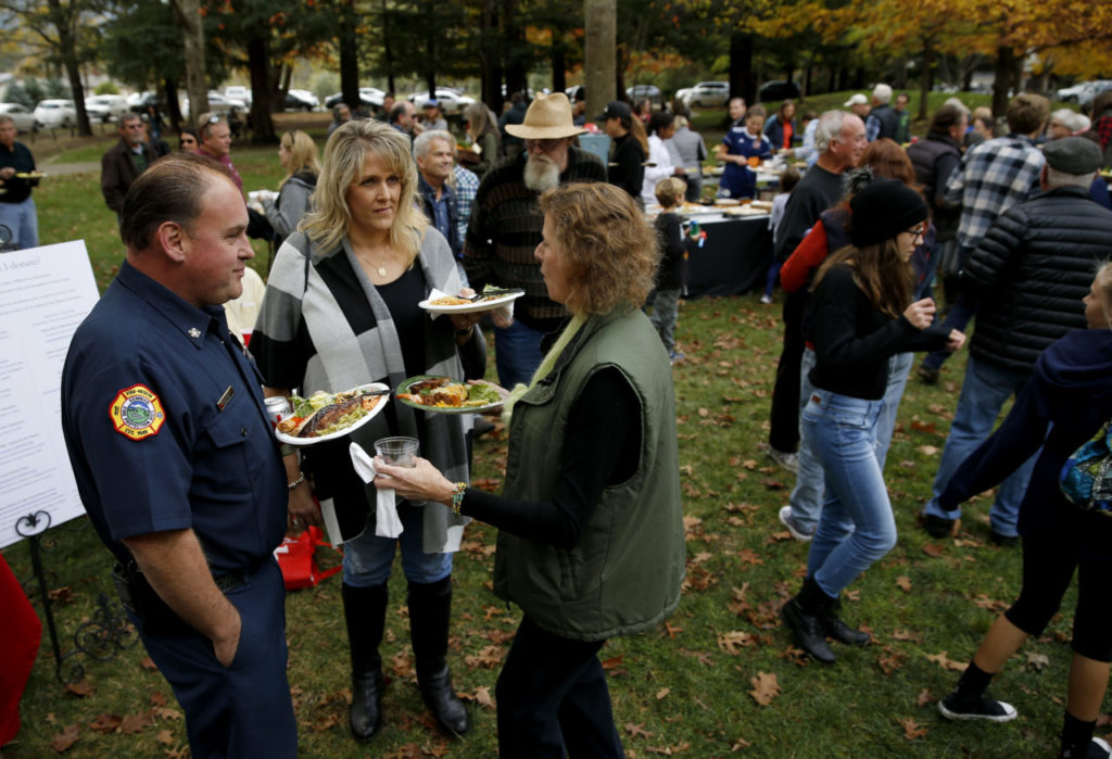 Kenwood Fire Chief Daren Bellach, left, and his wife Michelle talk with Gail Yee, right, during a community potluck to thank the Kenwood firefighters at Plaza Park in Kenwood, on Sunday, November 12, 2017. (Photo by Beth Schlanker) 