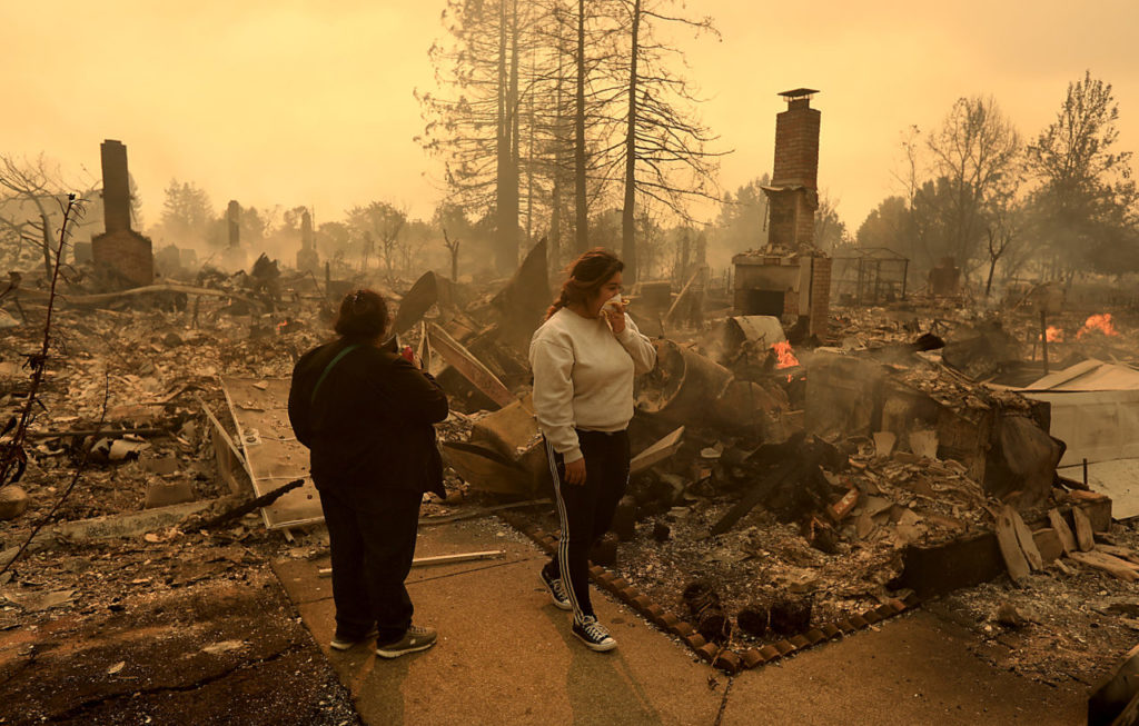 Maria Flores and her daughter-in-law Morelia Gaspar look over the ruins of Flores' home in Santa Rosa, Monday Oct. 9, 2017 near Coffey Park. (Photo by Kent Porter)