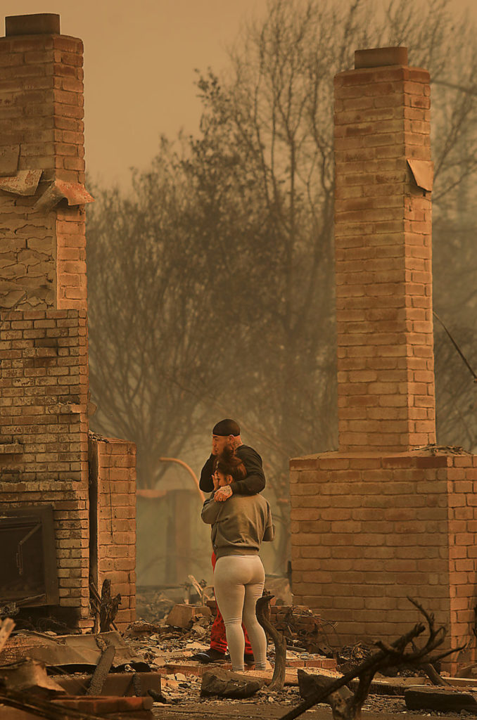 Darin Garcia looks at the remains of his home he's lived in for nearly 40 years as he embraces Ashley Alva s, Monday Oct. 9, 2017 in the Coffey Park area of Santa Rosa. (Photo by Kent Porter)