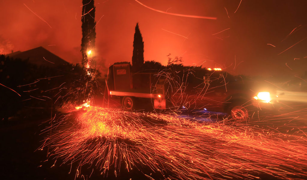 In Kenwood, a winery worker moves his work truck away from flame, Monday Oct. 9, 2017. (Photo by Kent Porter)