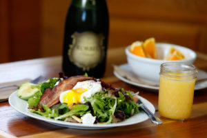 Breakfast salad of local lettuces, soft poached egg, crispy bacon, sauteed mushrooms, poached potatoes, fresh red onion, avocado, Pugs Leap chevre, and apple cider vinaigrette dressing and a mimosa at Estero Cafe in Valley Ford, California on Wednesday, January 27, 2016. (Alvin Jornada / The Press Democrat)