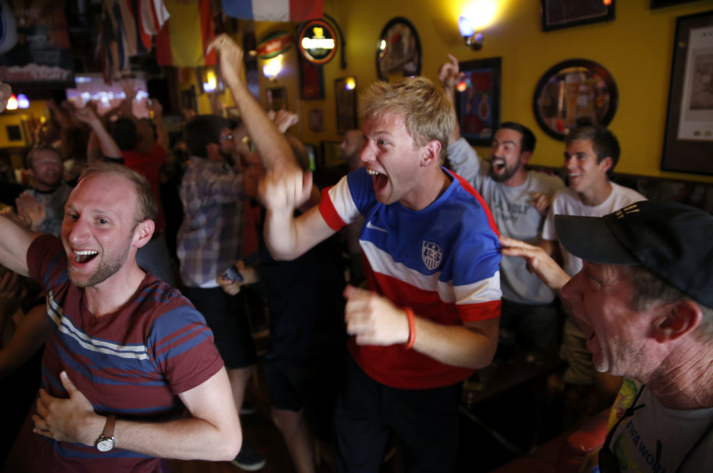 6/23/2014:A1: Mason Williams, center, and Dan Reichman, left, react Sunday at the Sweet Spot in Santa Rosa as the U.S. scores in the World Cup. PC: Mason Williams, center, and Dan Reichman, left, react as the United States scores a goal to tie the game 1-1 against Portugal in the World Cup at The Sweet Spot Pub & Lounge in Santa Rosa, on Sunday, June 22, 2014.(BETH SCHLANKER/ The Press Democrat)