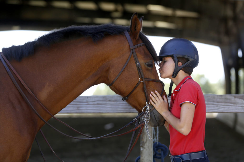Cardinal Newman senior Rachael McGregor gives her horse Lenny a kiss before riding him at Chocolate Horse Farm in Petaluma on Wednesday, May 30, 2018. (Beth Schlanker/ The Press Democrat)