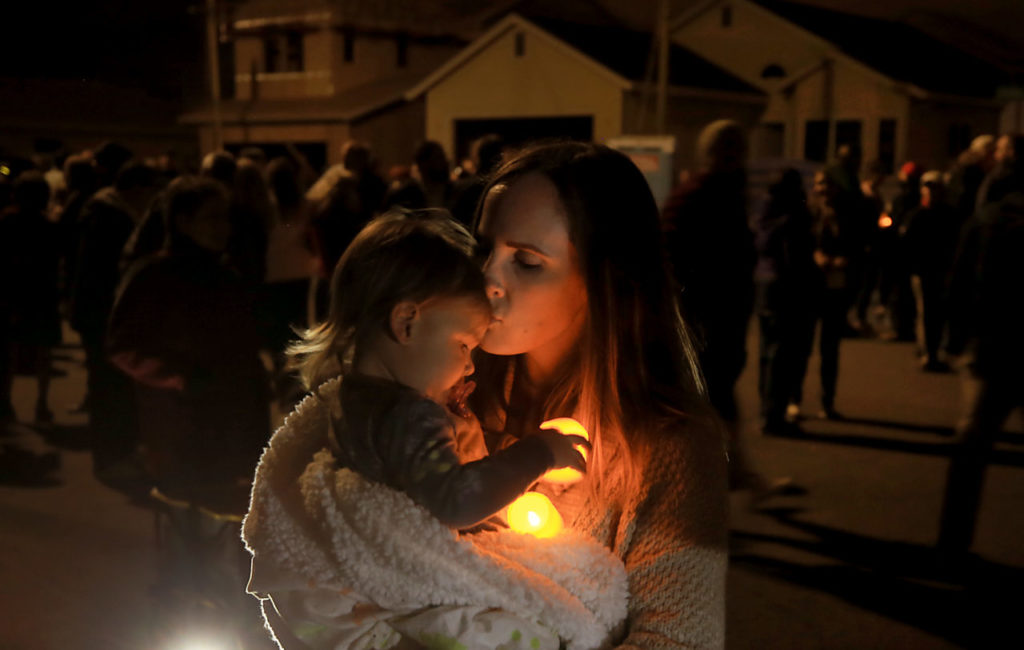 Emily Lyons and her daughter Hailey, 1, who moved from Coffey Park seven months before the Tubbs fire, snuggle during the marking the one year anniversary, Tuesday, Oct. 9, 2018. (Kent Porter / The Press Democrat) 2018