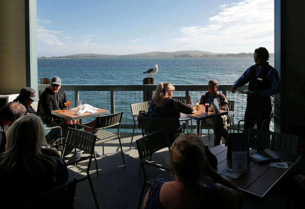 Visitors dine and enjoy drinks outside the Inn at the Tides restaurant in Bodega Bay, California on Saturday, July 15, 2017. (Alvin Jornada / The Press Democrat)