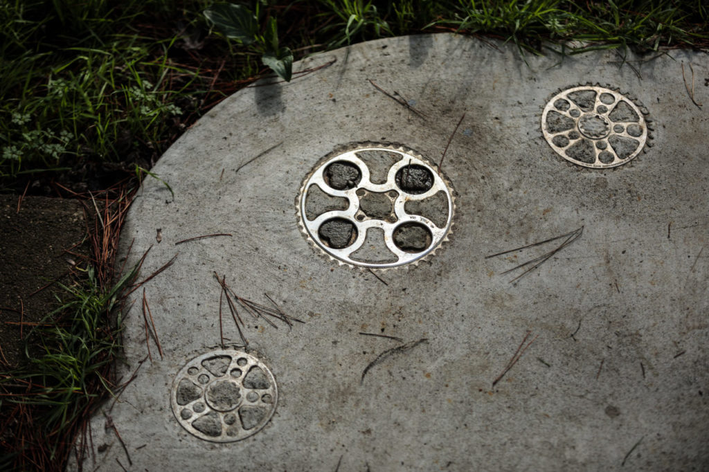 Curtis Inglis, and some of the bikes he makes. Gears imbedded in the concrete entry to his workshop.