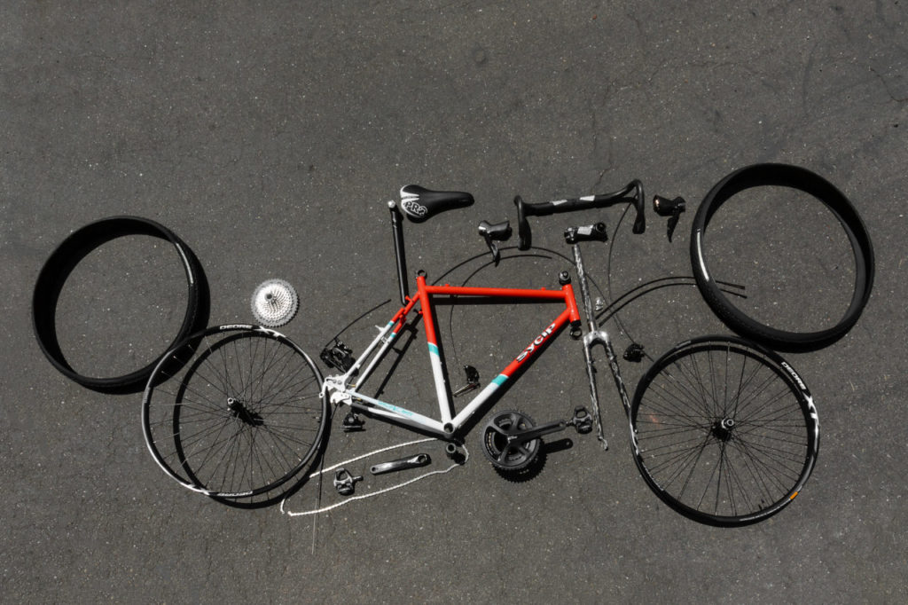 Jeremy Sycip, builder of custom bikes with some of his bikes and an exploded view of a bike