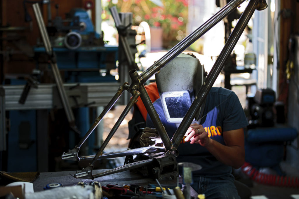 Jeremy Sycip, builder of custom bikes with some of his bikes and an exploded view of a bike