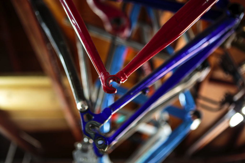Jeremy Sycip, builder of custom bikes with some of his bikes and an exploded view of a bike