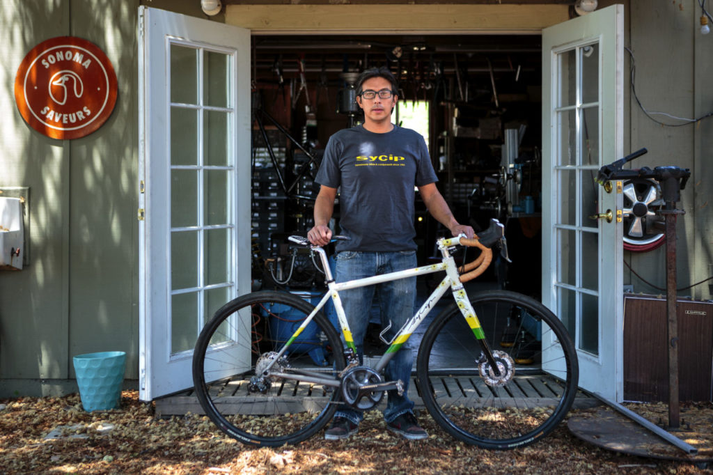 Jeremy Sycip, builder of custom bikes with some of his bikes and an exploded view of a bike
